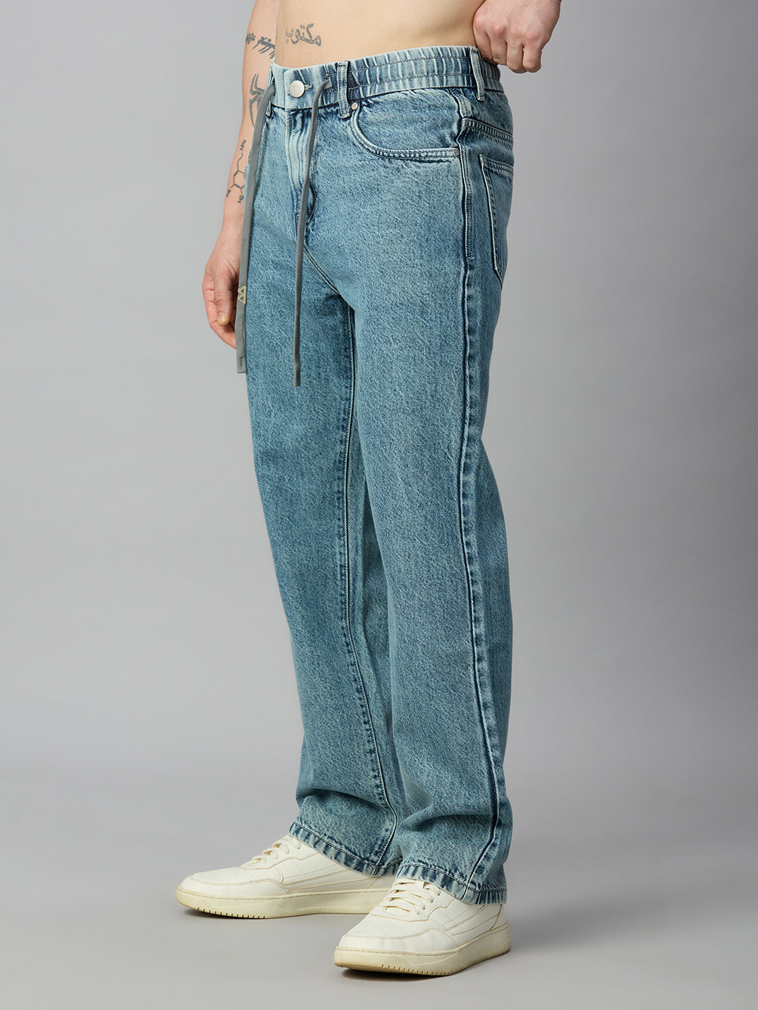 Men's relaxed baggy denim jeans featuring a light blue wash, elastic waistband, and drawstring – right side view