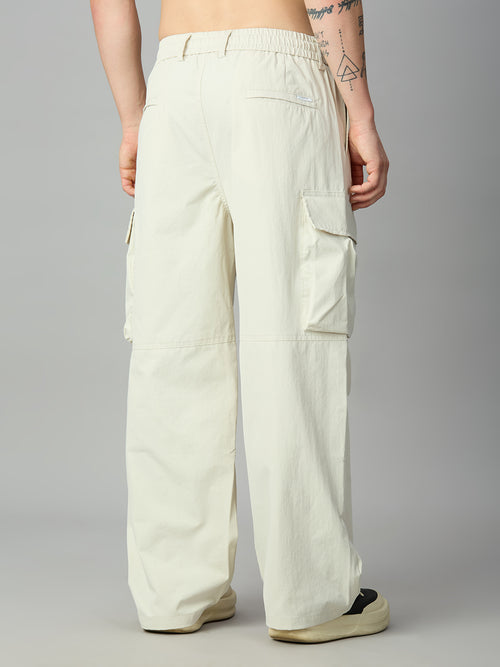 A person shown from the back wearing off-white wide-leg cargo pants with side flap pockets, photographed against a plain light gray studio background.