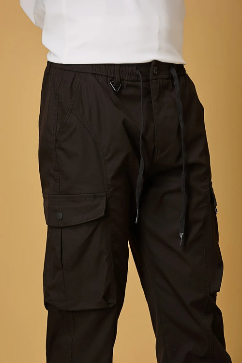 Close-up of black cargo pants, waist string and pocket detailing.