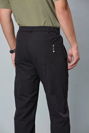 Close-up of black trousers belt, elastic waist, and pleated design details