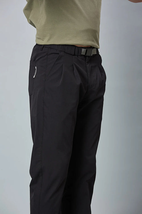Close-up of black trousers belt, elastic waist, and pleated design details