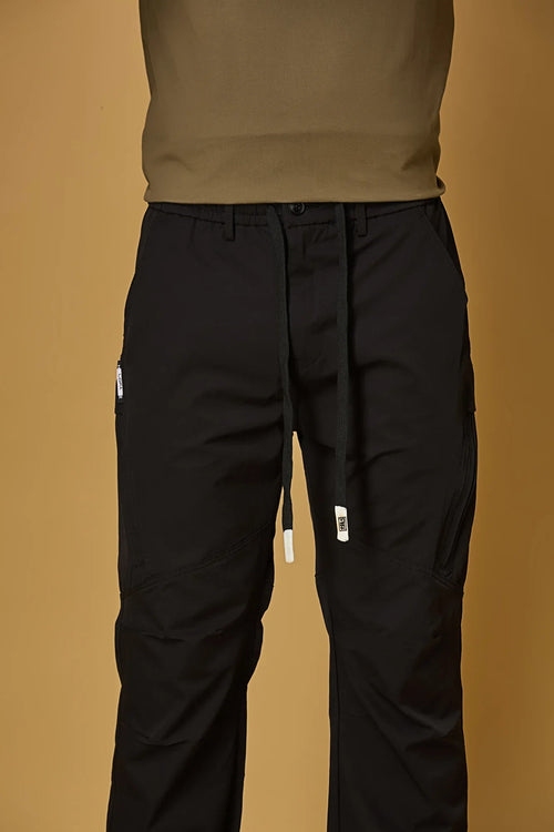 Close-up of black trousers waist strings, side pockets, and smooth fabric texture.