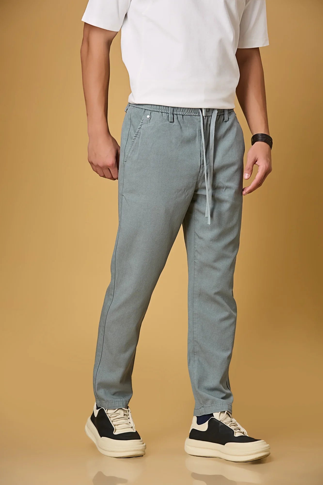 Close-up of waist string, press button, and fabric texture on Aqua Blue trousers.