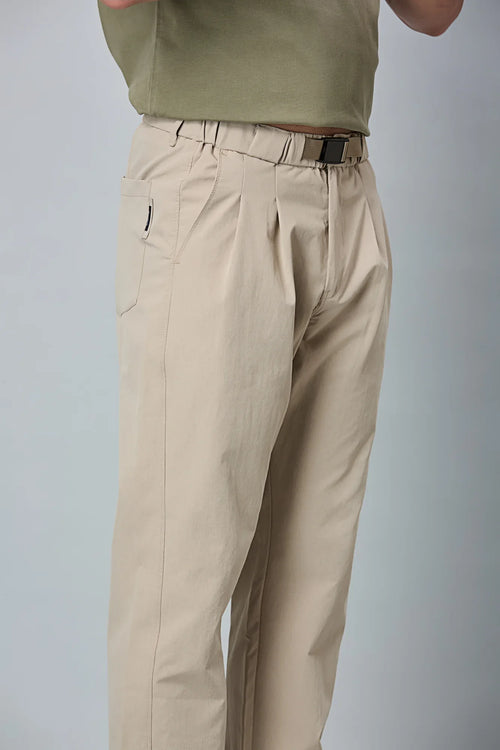 Close-up of khaki trousers belt, elastic waist, and pleated design details