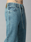 Close-up of elastic waistband and adjustable drawstring on men's light blue washed denim jeans