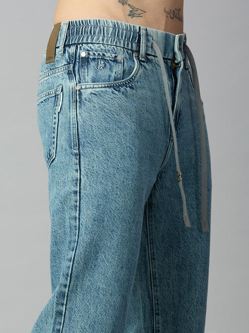 Close-up of elastic waistband and adjustable drawstring on men's light blue washed denim jeans