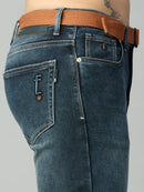Close-up of attached adjustable webbing belt and metal buckle on men's straight fit denim jeans | The Lofa