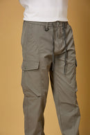 Close-up of grey cargo pants, waist string and pocket detailing.
