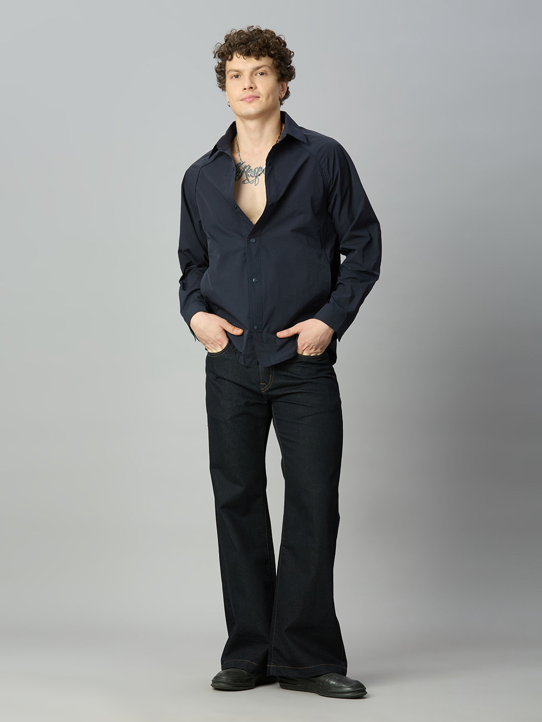 Model wearing The Lofa men's deep blue bootcut denim jeans styled for a modern casual look